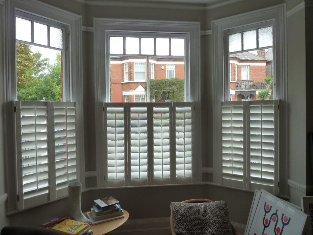 white wooden shutters for bay windows